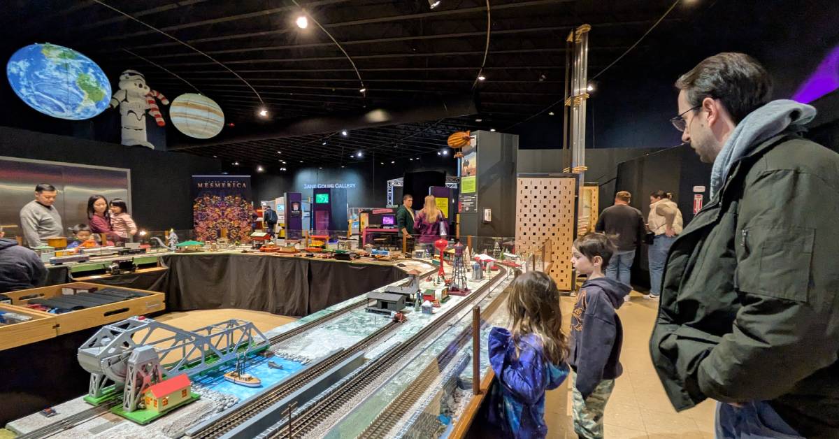 family looks at train set at misci