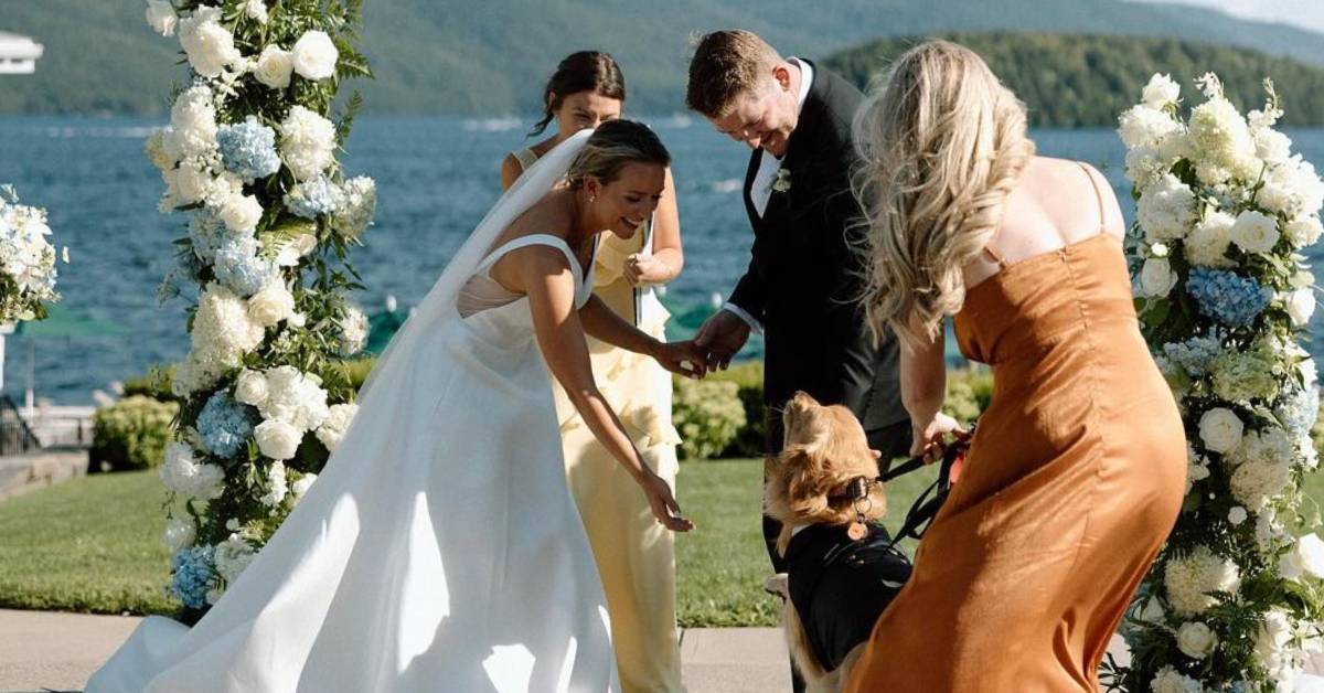 bride and a few wedding party members with a dog by the lake