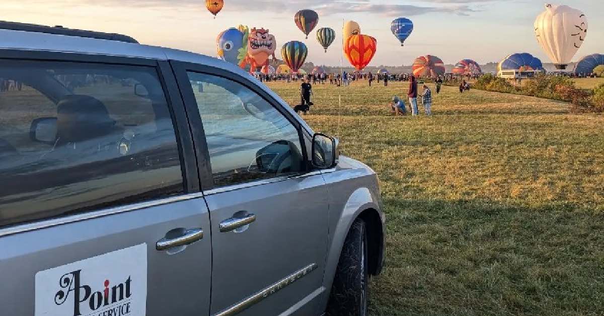 Car parked watching balloons