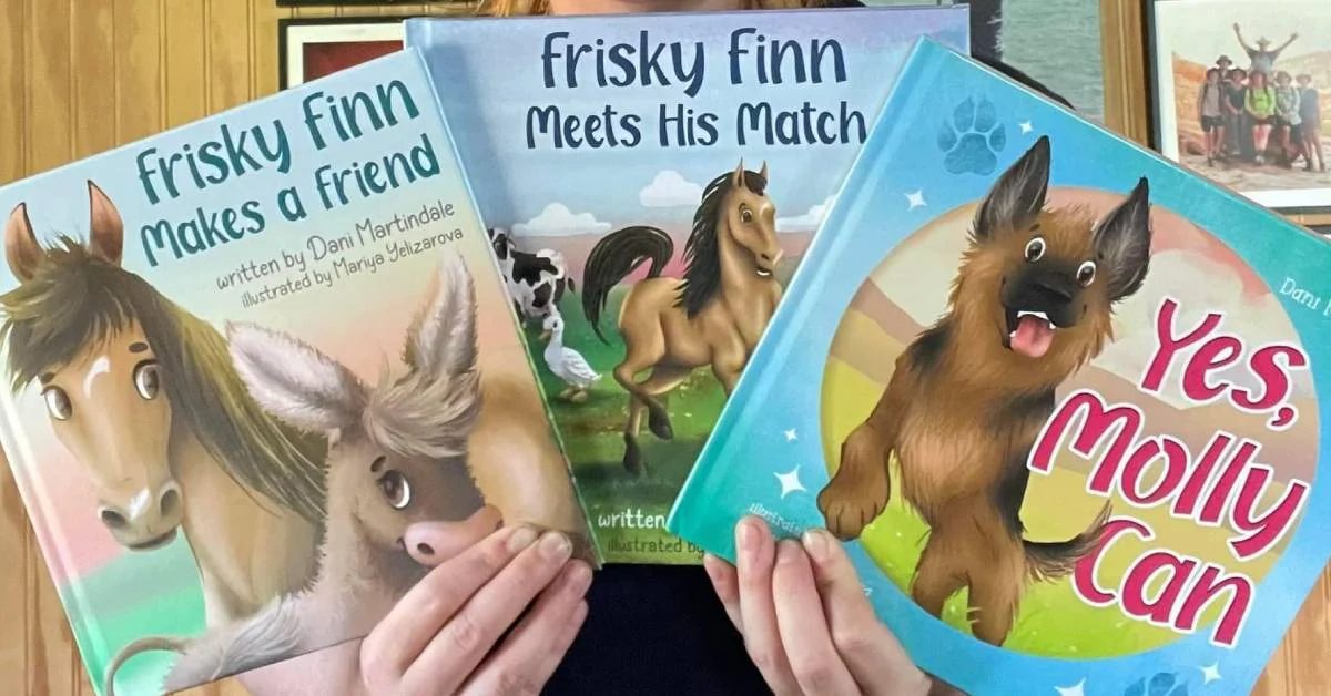 hands holding up three children's books