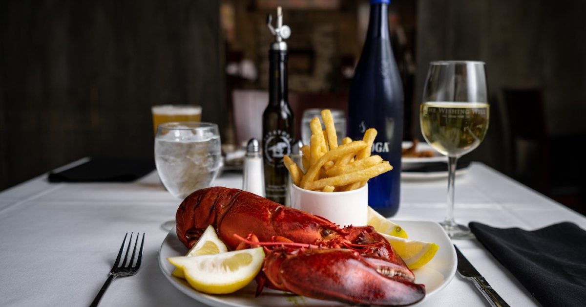 dinner table with lobster, fries, and drinks
