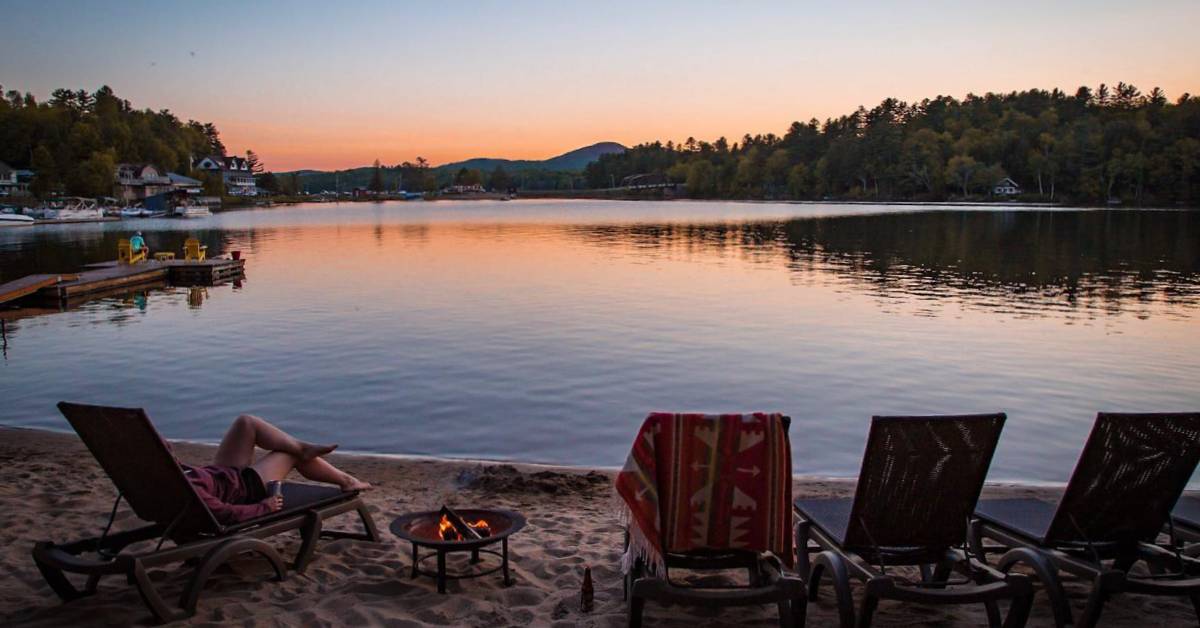 woman relaxes by lake beach at dusk