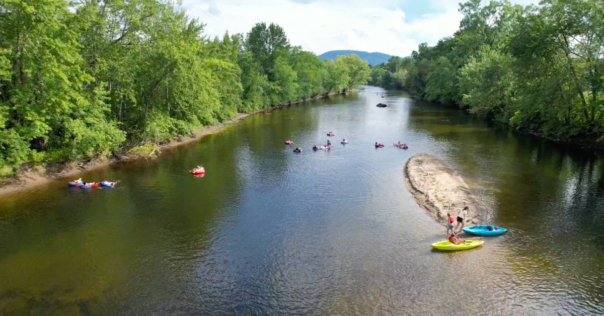 aerial view of people swimming, tubing, and kayaking in schroon river