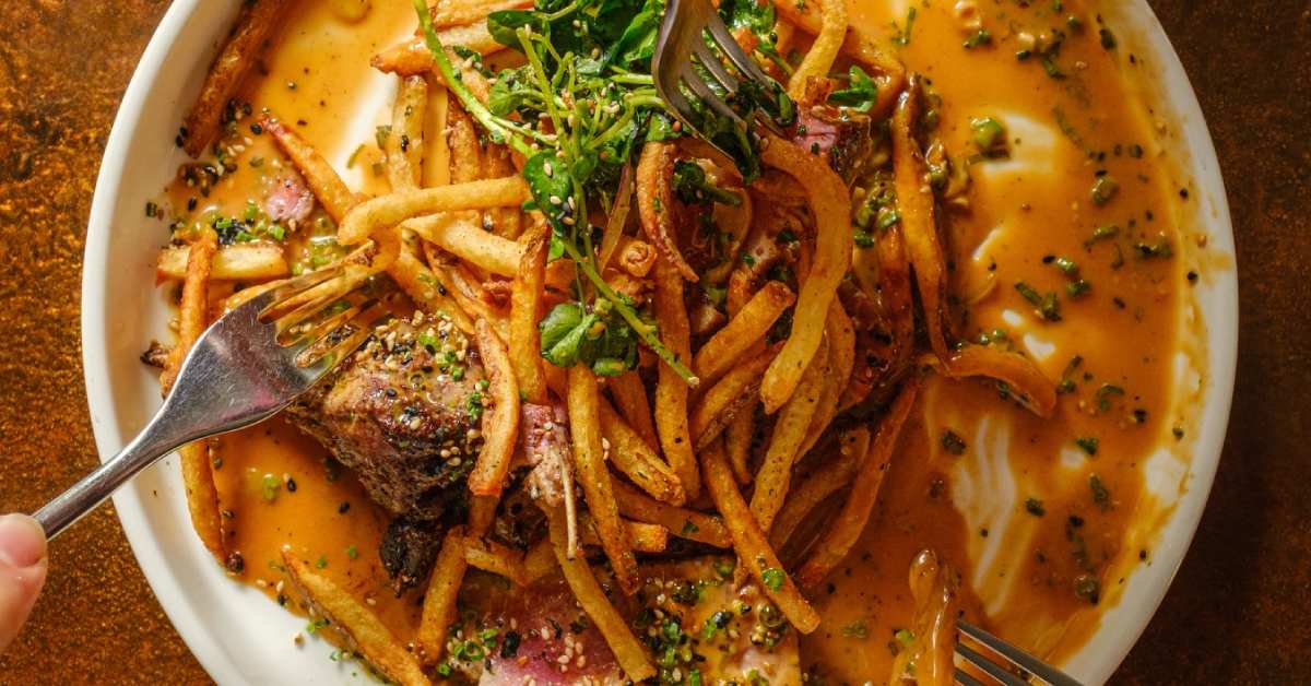french fries with toppings and forks in dish