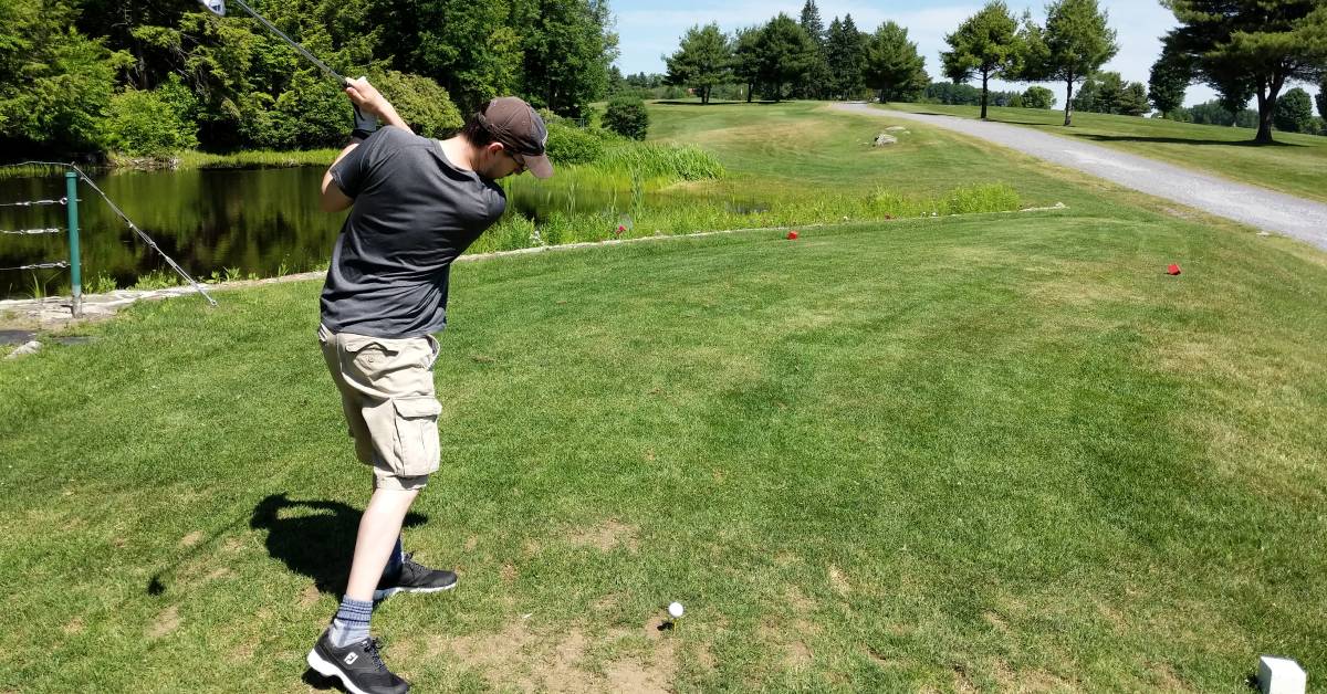 man golfs