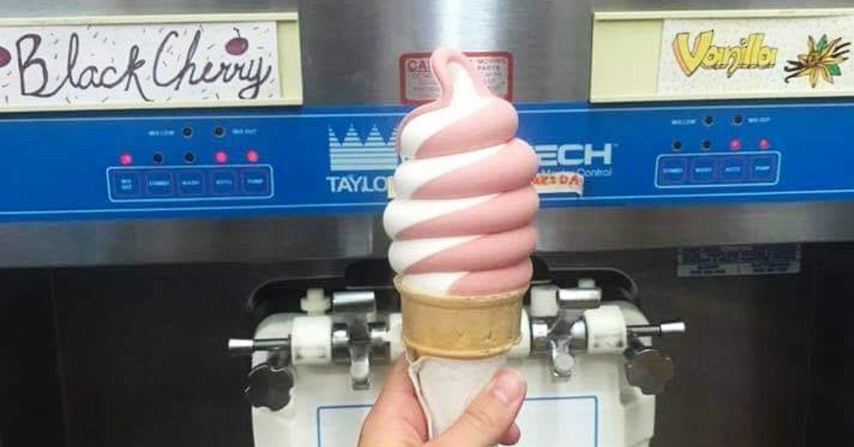 person holding a black cherry twist ice cream cone