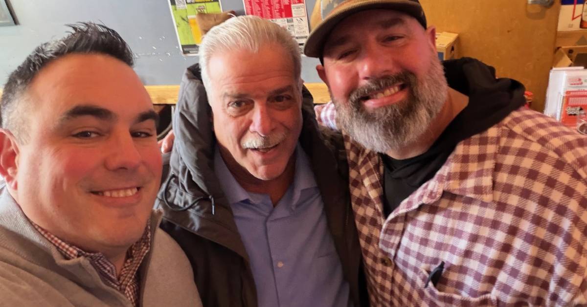 three men pose together