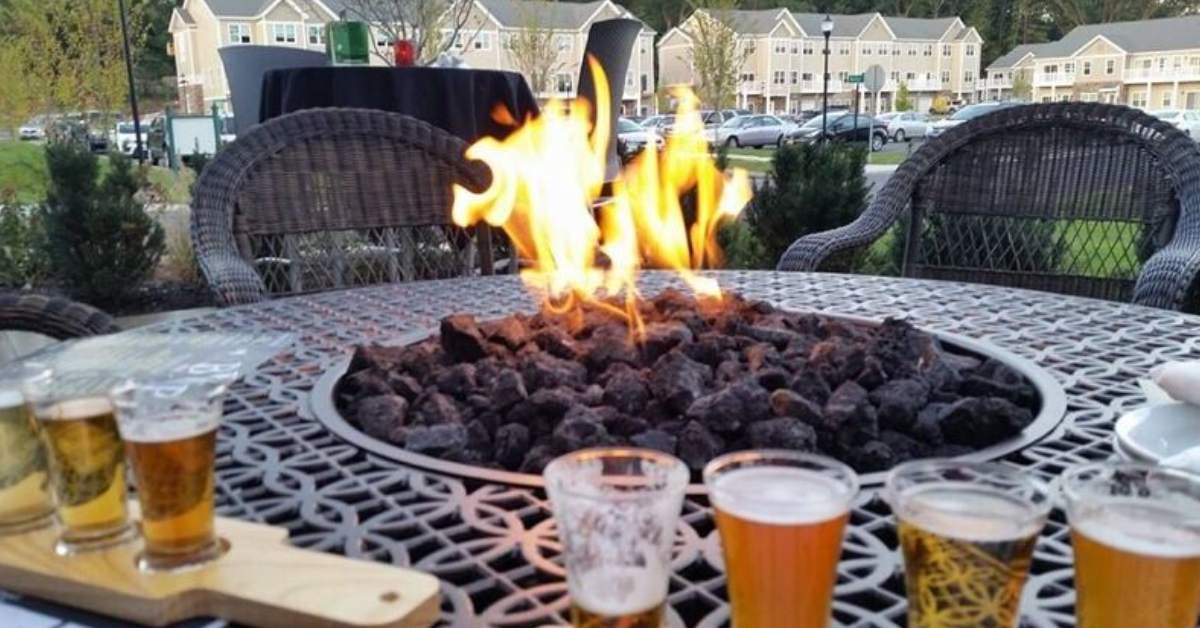 a patio table with a fire, and beer