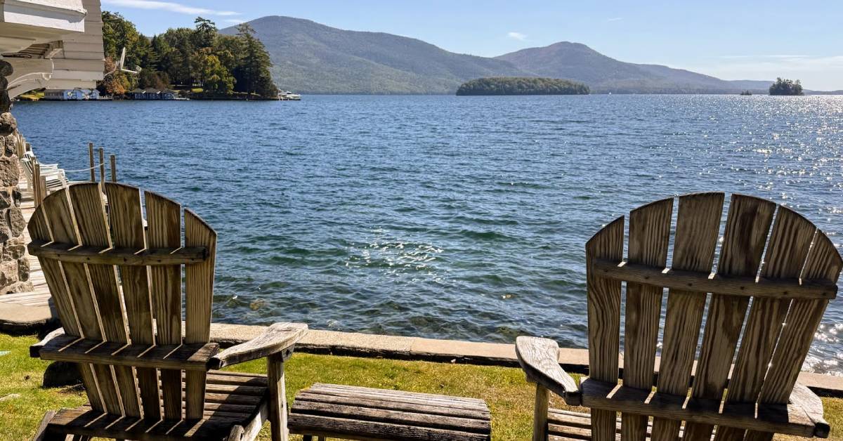 two adirondack chairs looking out at water