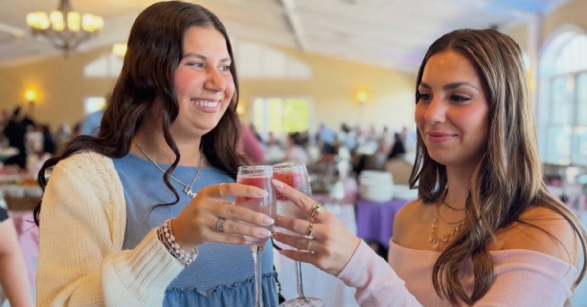 two women cheersing with wine glasses