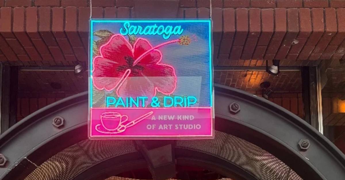 sign with a flower that says Saratoga Paint and Drip
