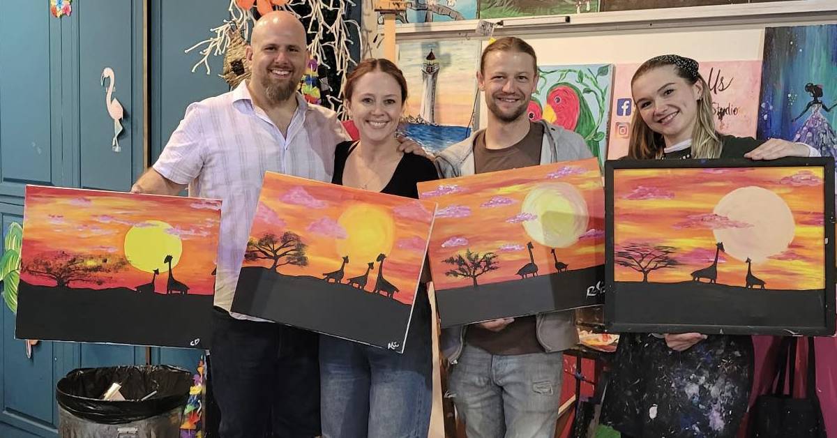 four people hold up their paintings