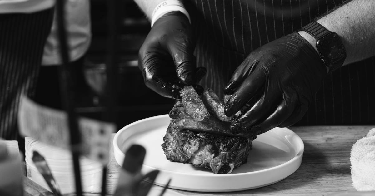 chef hands putting steak fries on a filet mignon