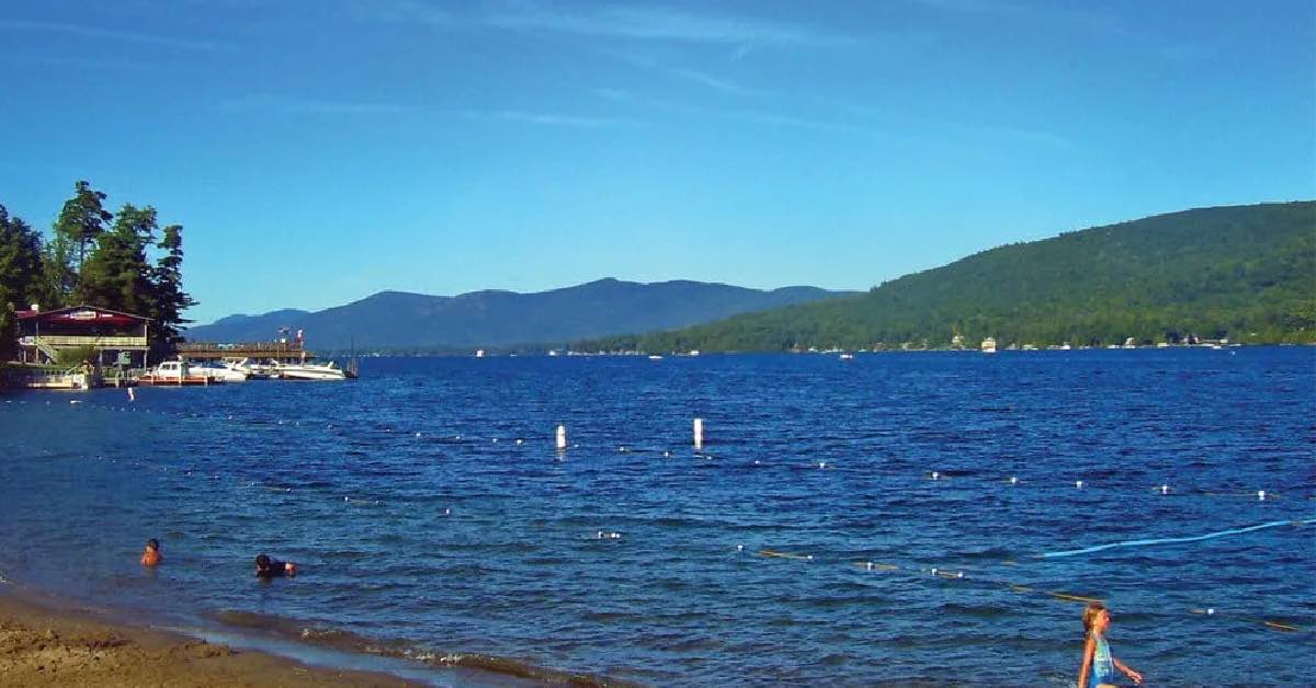 Million Dollar Beach on Lake George with sandy shoreline, swimming area, and Adirondack Mountain views