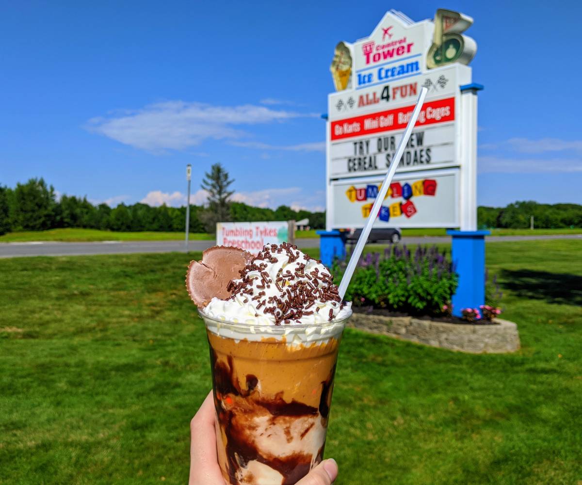 peanut butter trash can ice cream held up against control tower ice cream sign