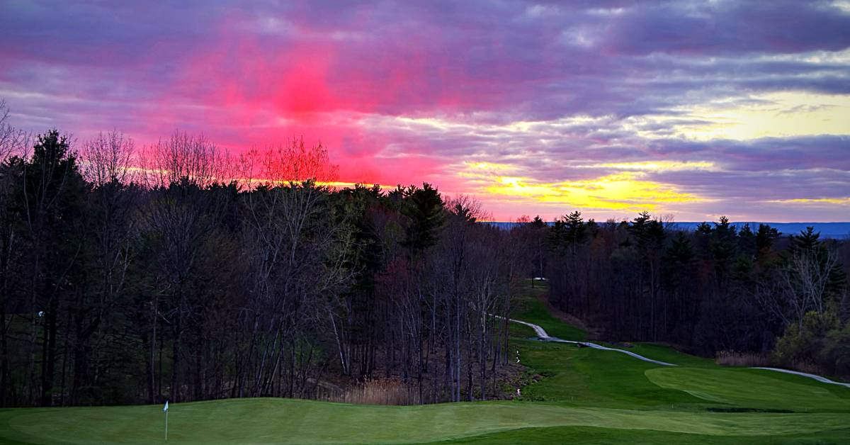 view of golf course with sunset