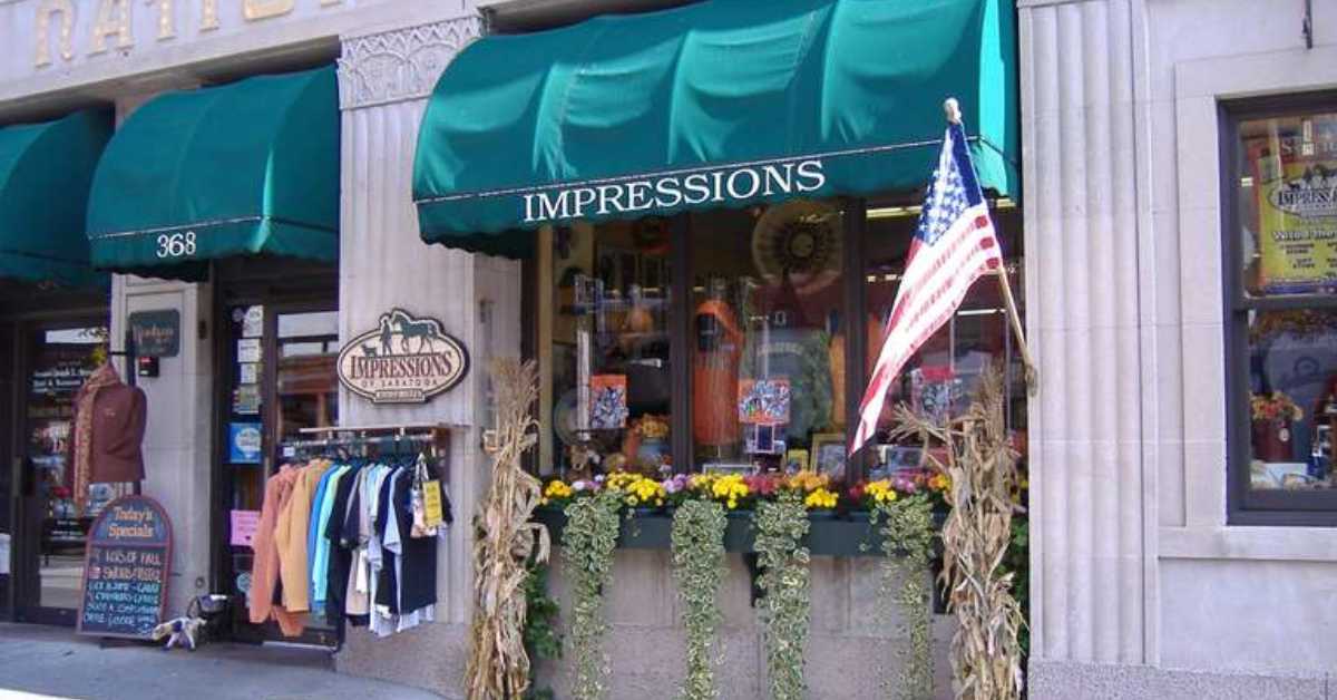 store front with Impressions written on awning and flowers in the window