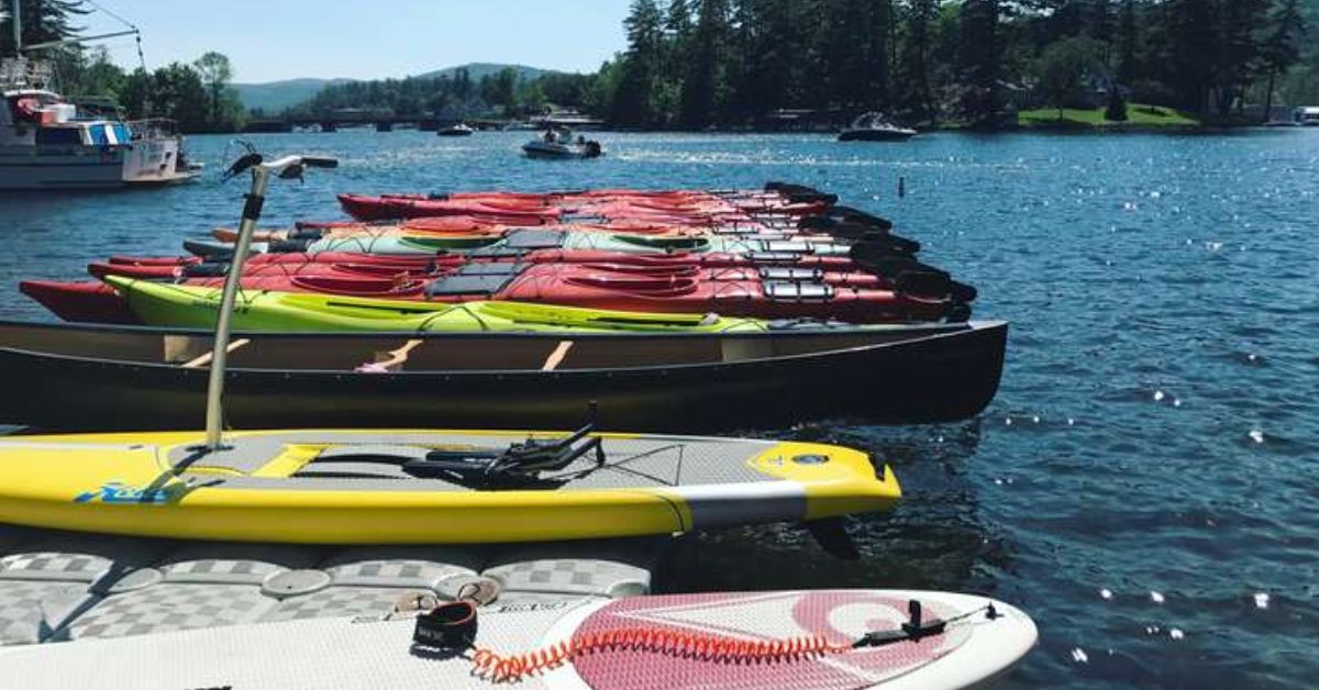paddleboards and kayaks lined up in the water