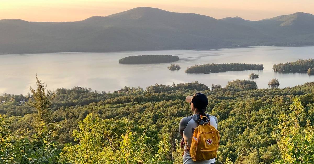 hiker looks out at mountain summit