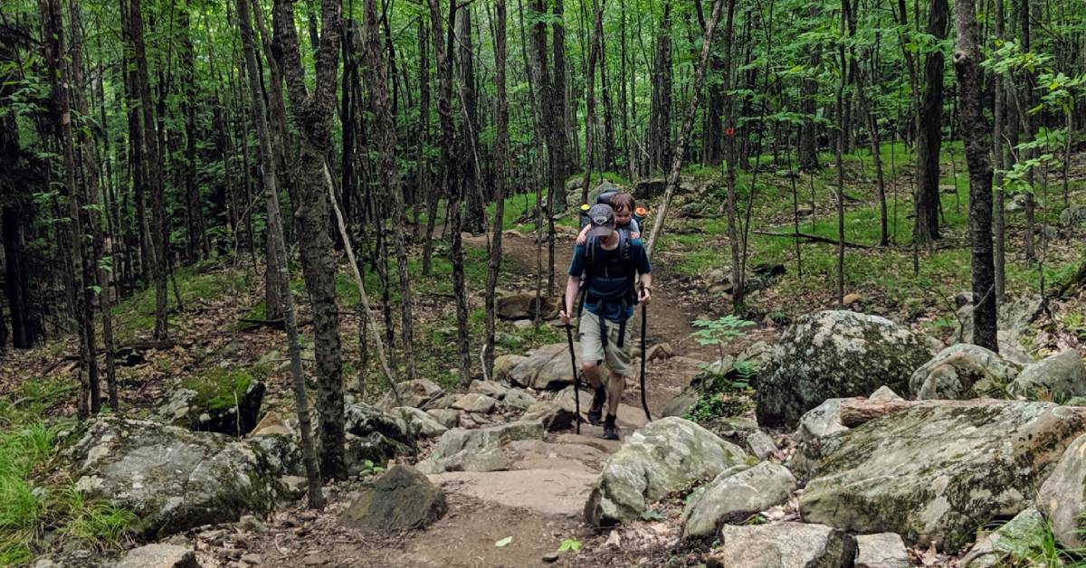 hiker with toddler on back