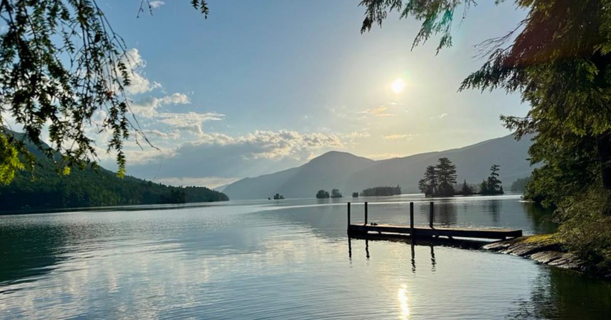 sun over lake with dock