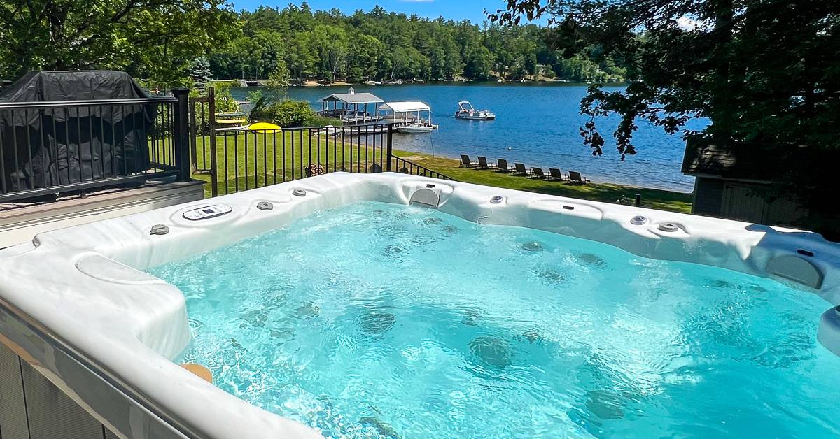 outdoor hot tub with lake in background