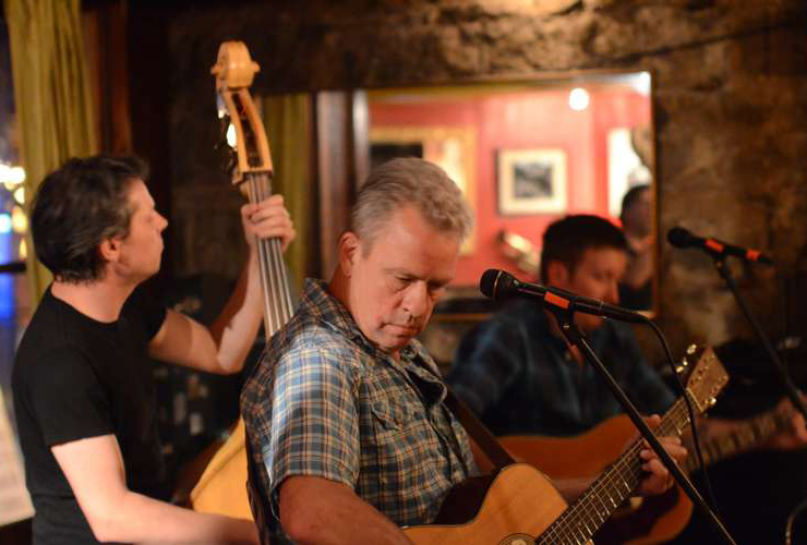 a man playing a guitar in a bar