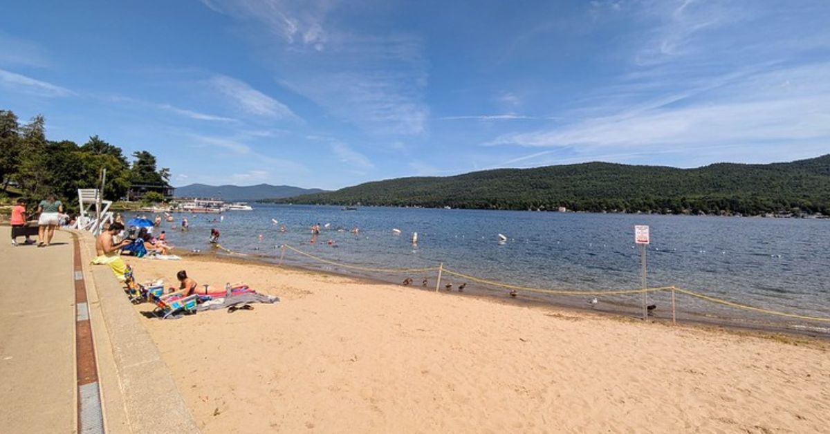 people relaxing on a sandy lake beach
