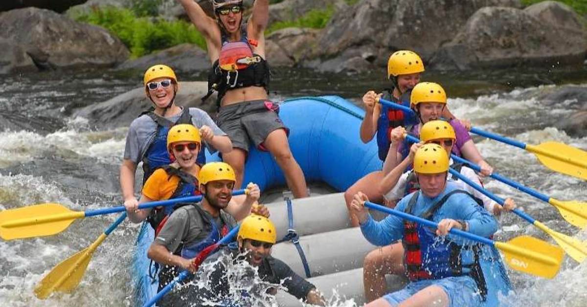 people on a raft in the river with paddles and helmets