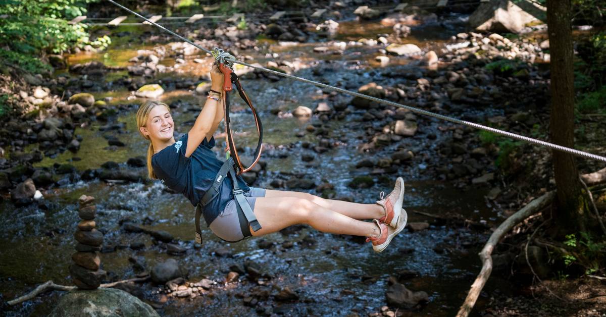 woman ziplining over river