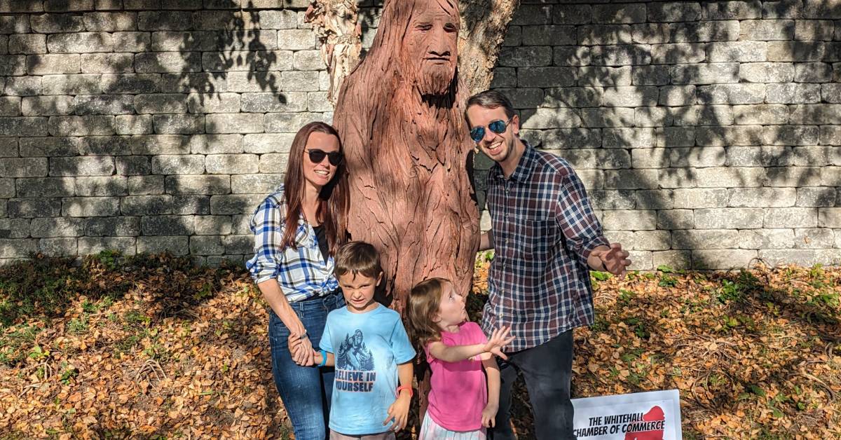 family poses with bigfoot statue