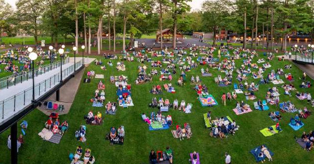 Guests relaxing on the SPAC lawn during a summer performance in Saratoga Springs.