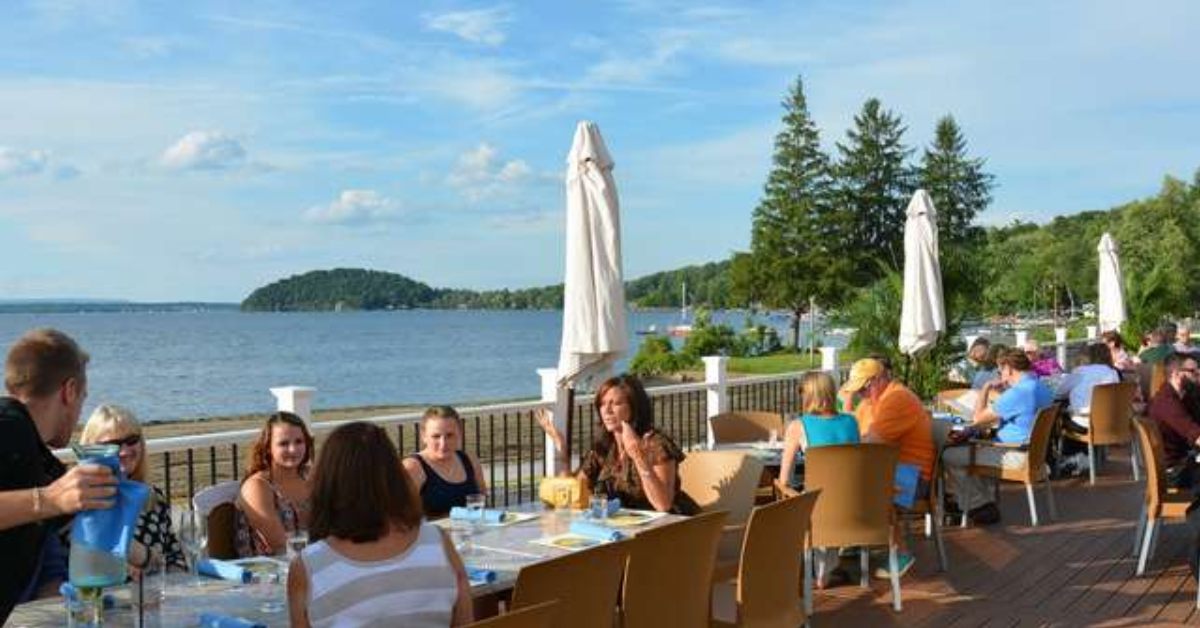 people sitting on a deck by the water