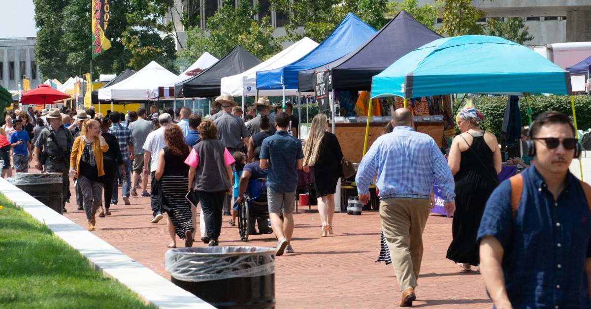people walking around a city plaza food festival