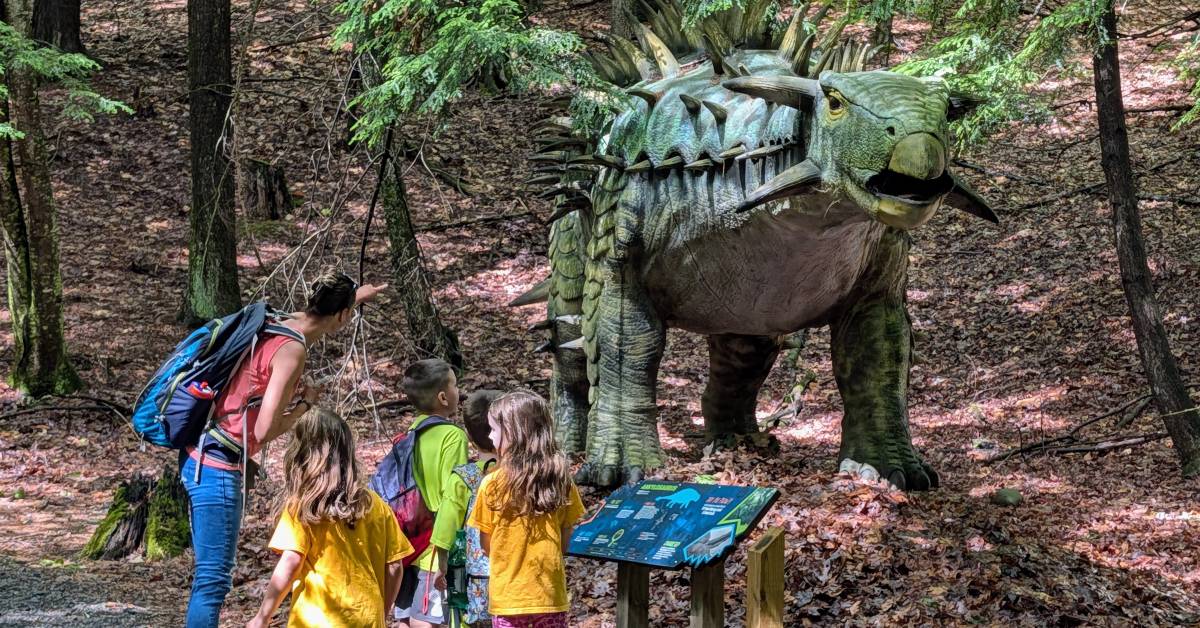 mom and kids look at dinosaur
