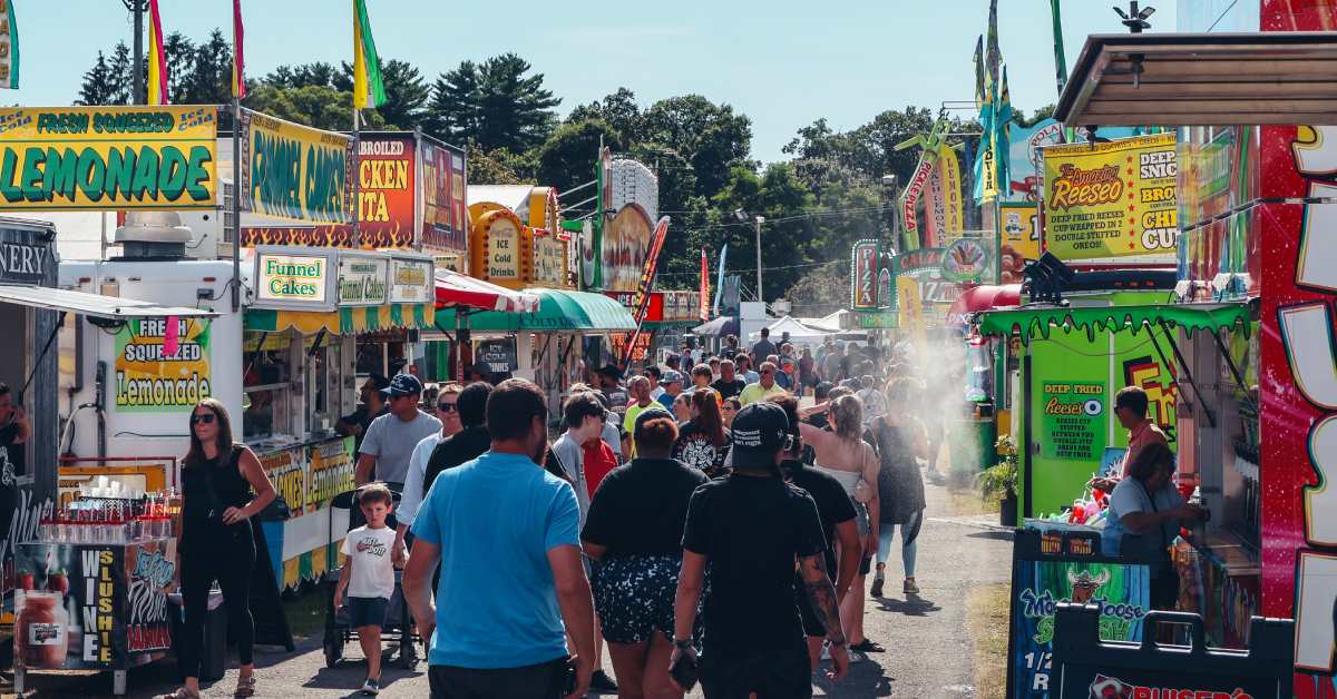 people walking around fair food booths