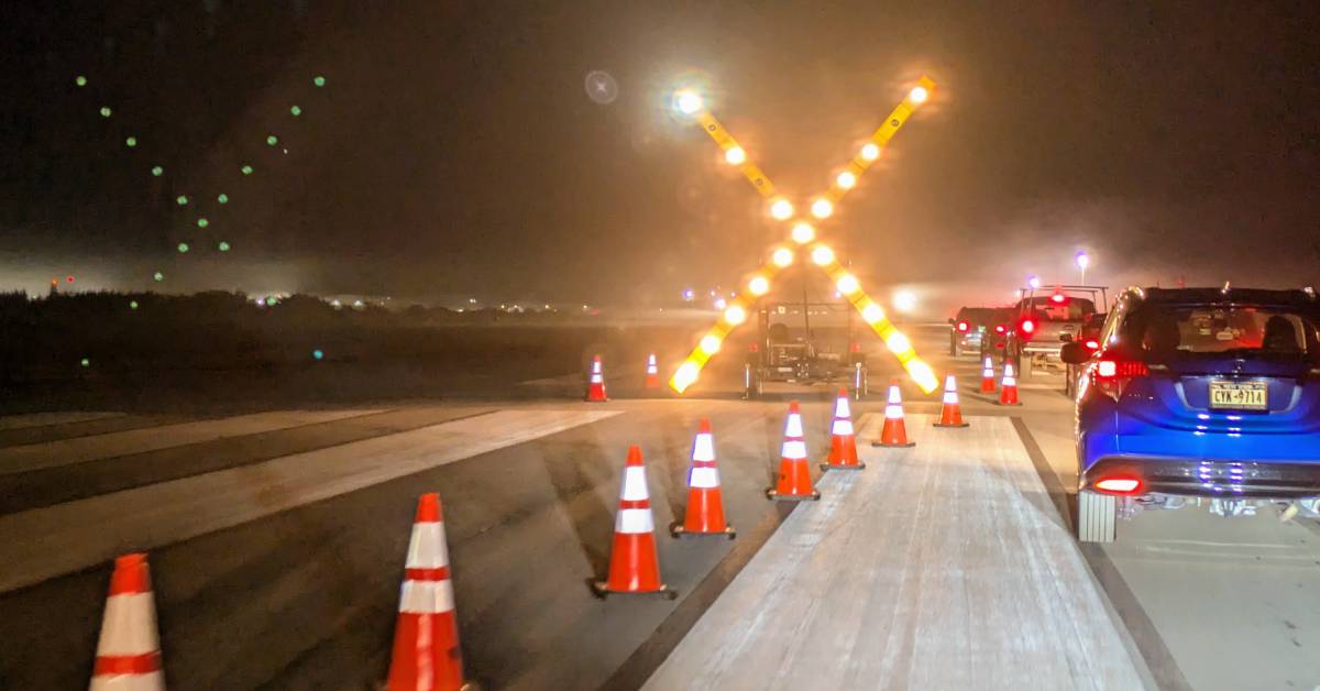 Xs on airport while cars drive in