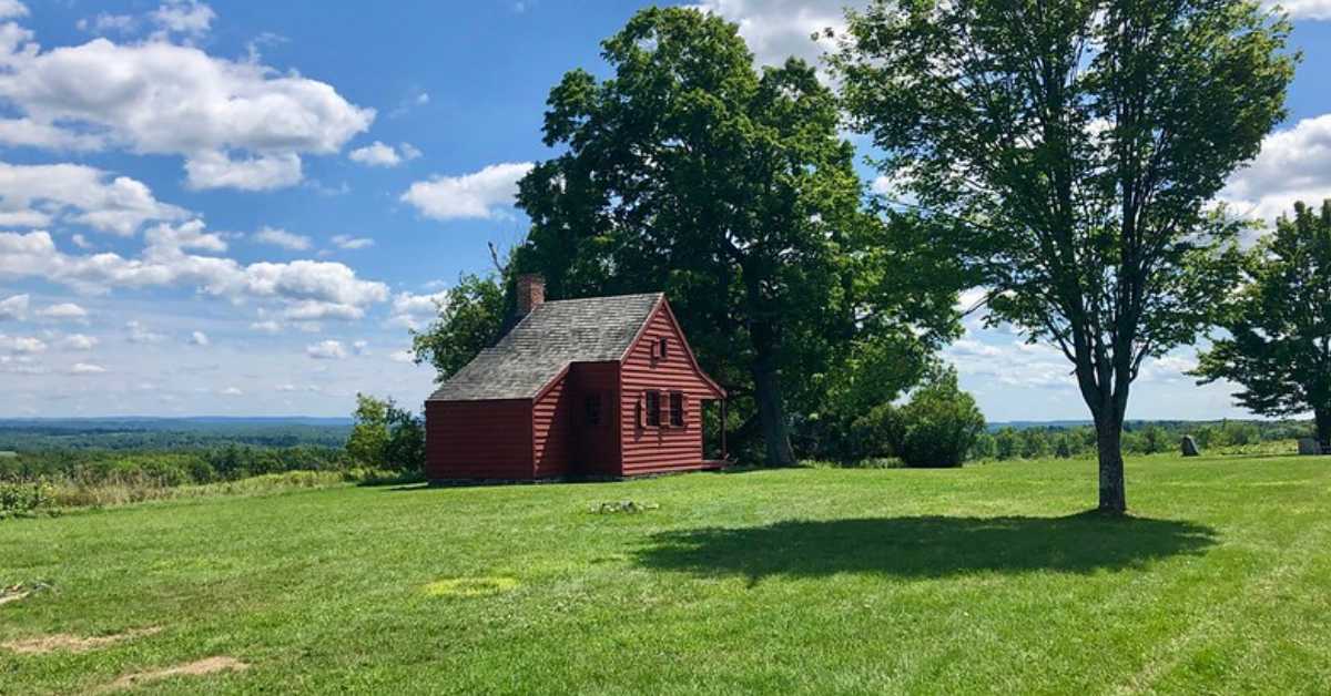 a red cabin on a grassy field