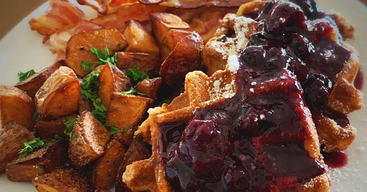 waffles topped with blueberries with a side of potatoes