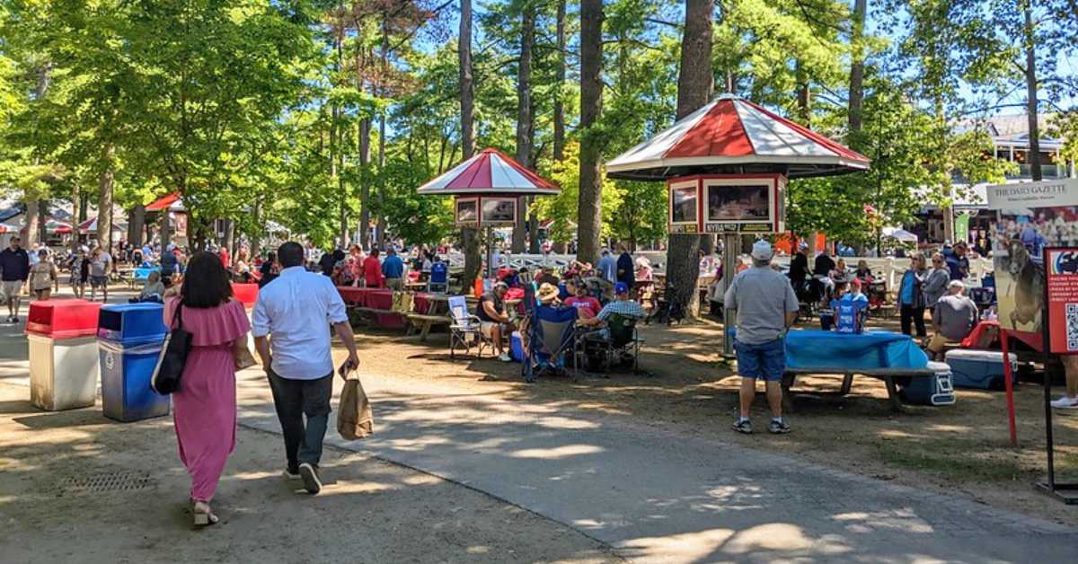 Saratoga Race course picnic area with people seated and walking around