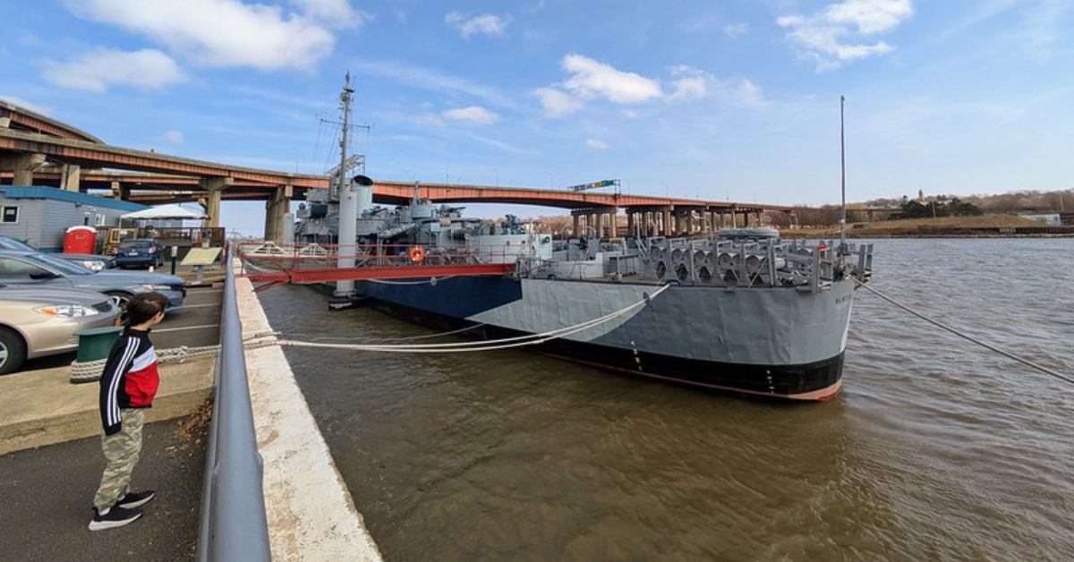 a boy looking at the USS Slater