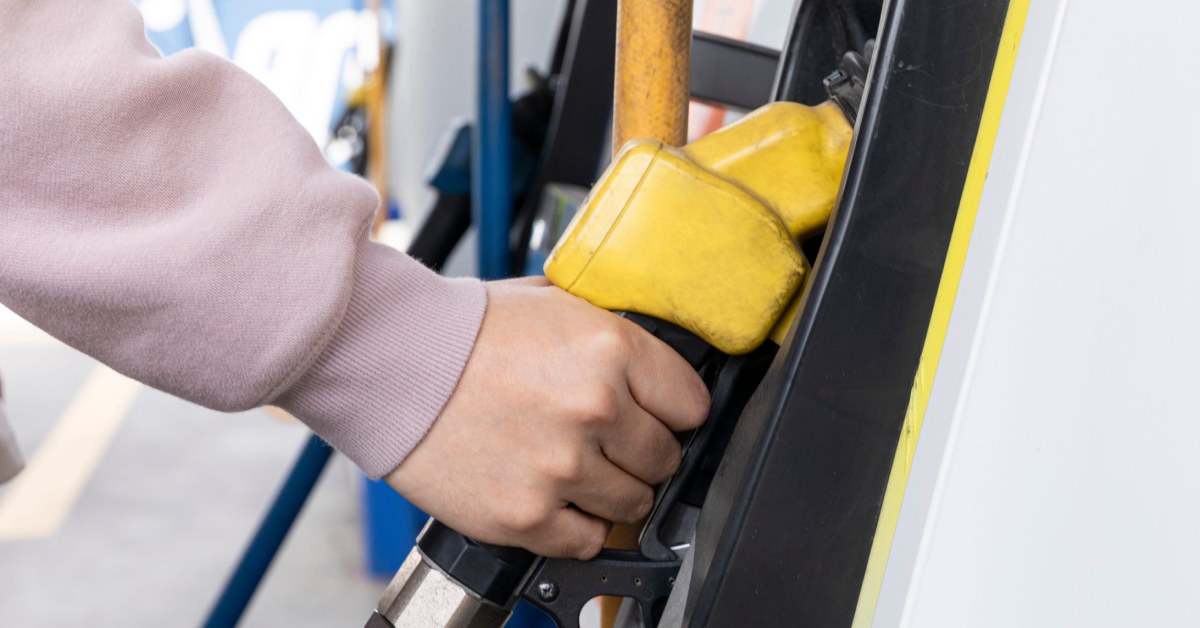 hand holding yellow gas pump