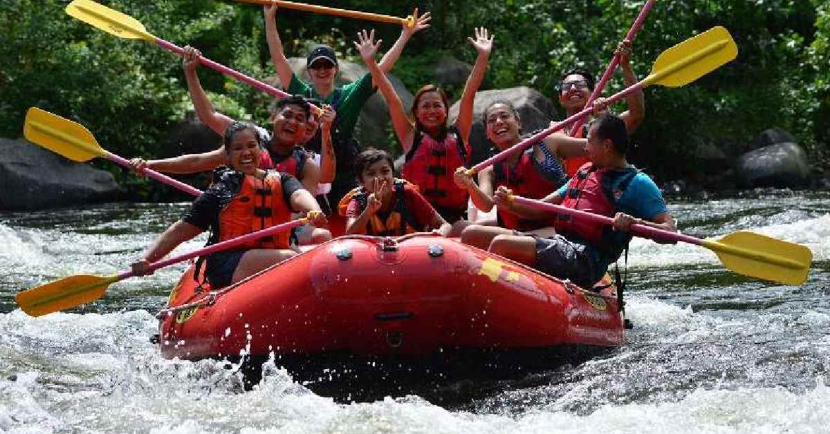 people holding paddles on a raft