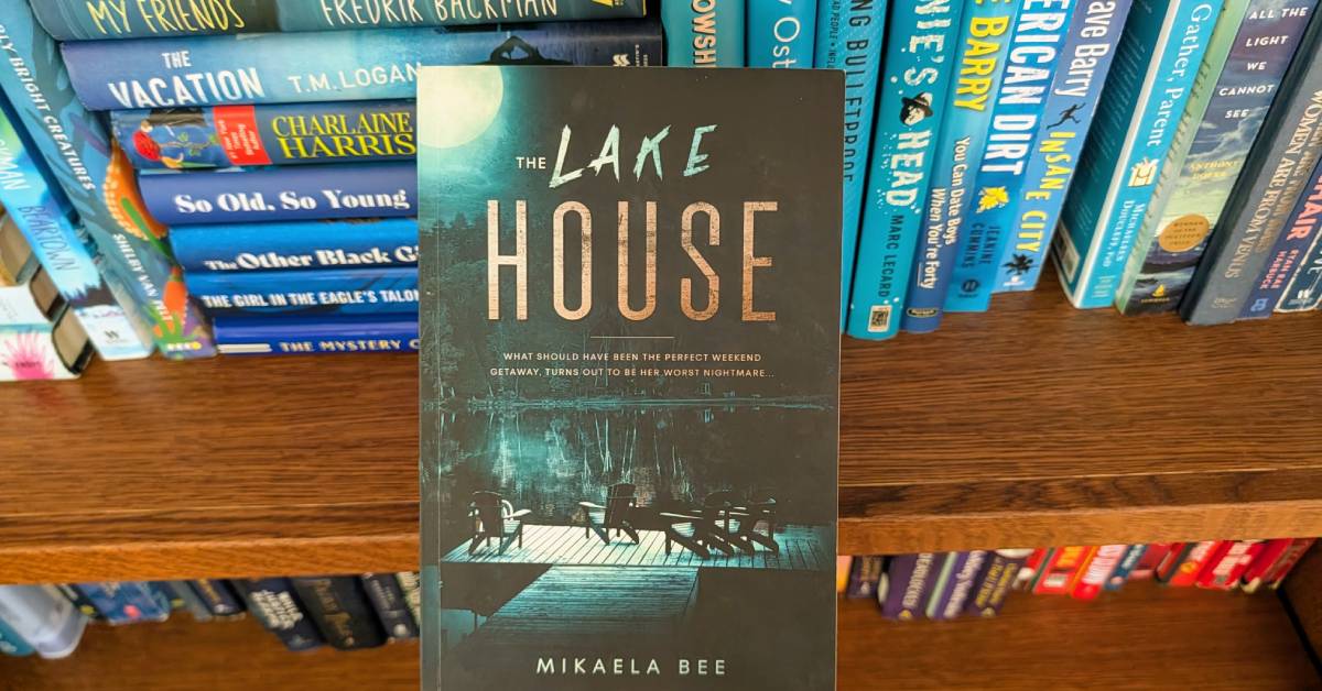 the lake house by  mikaela bee held up against bookcase