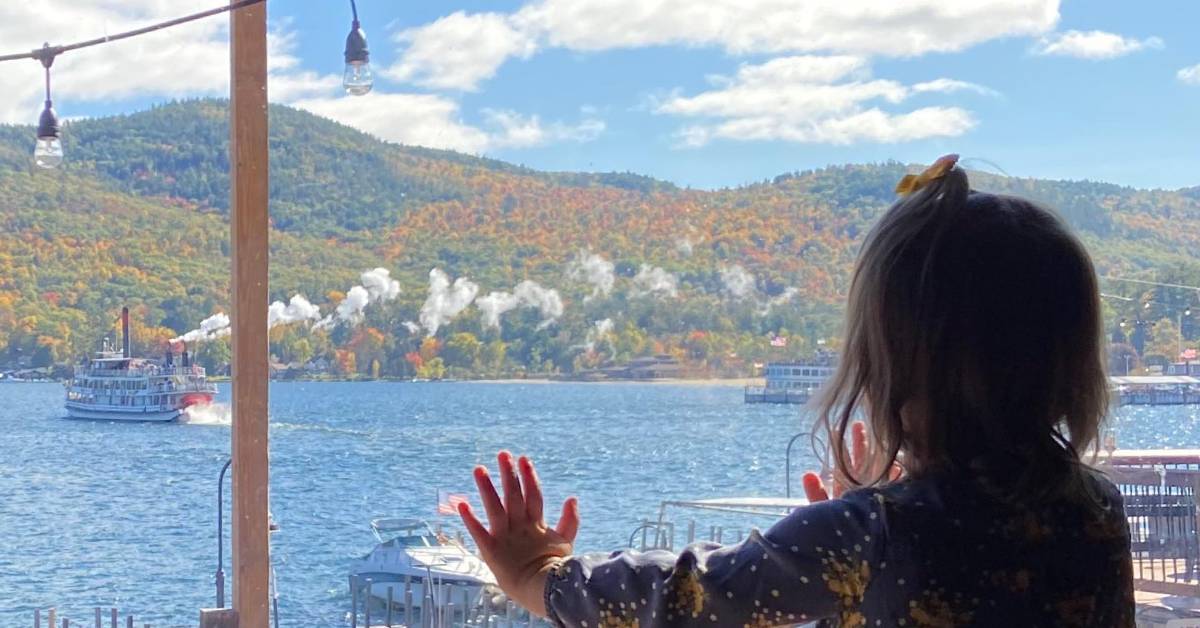 a girl looking at boats on a lake