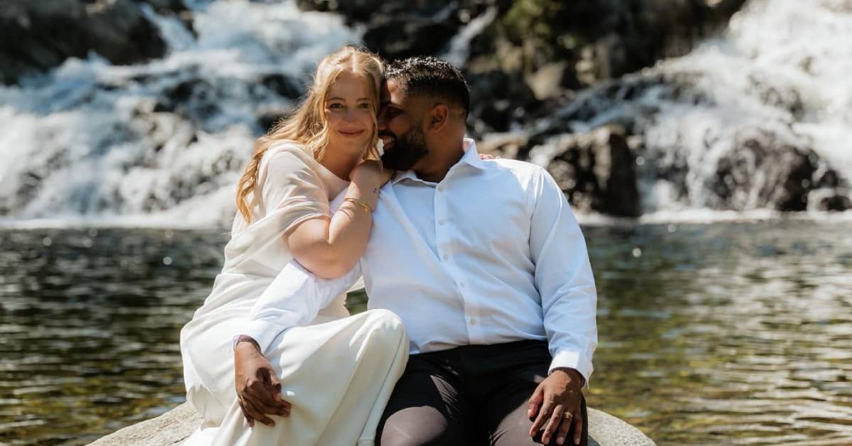 bride and groom in front of waterfall