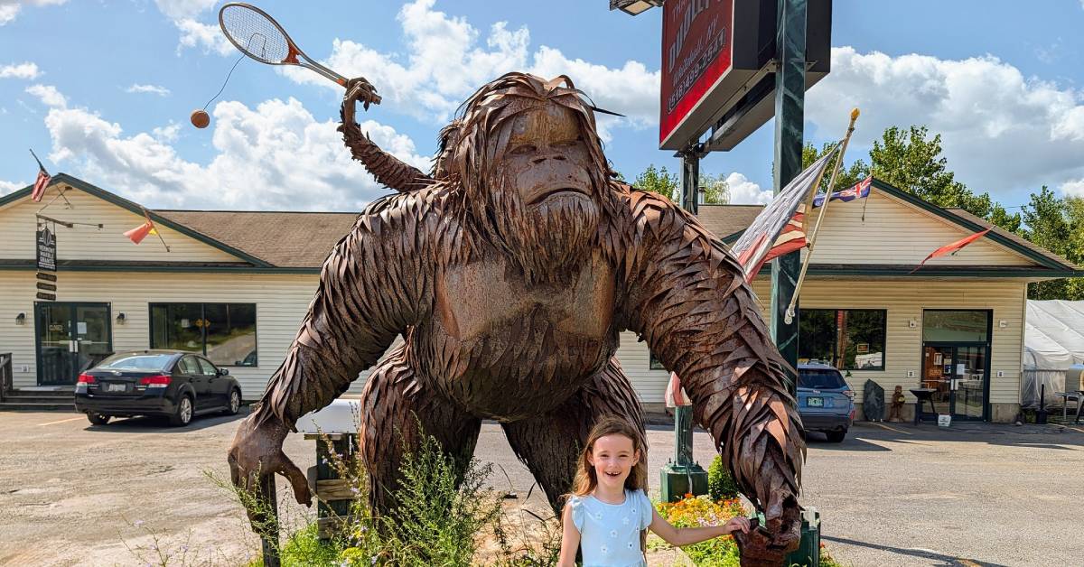 little girl poses by bigfoot statue