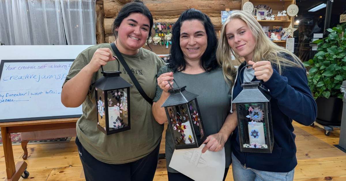 three women holding painted lanterns