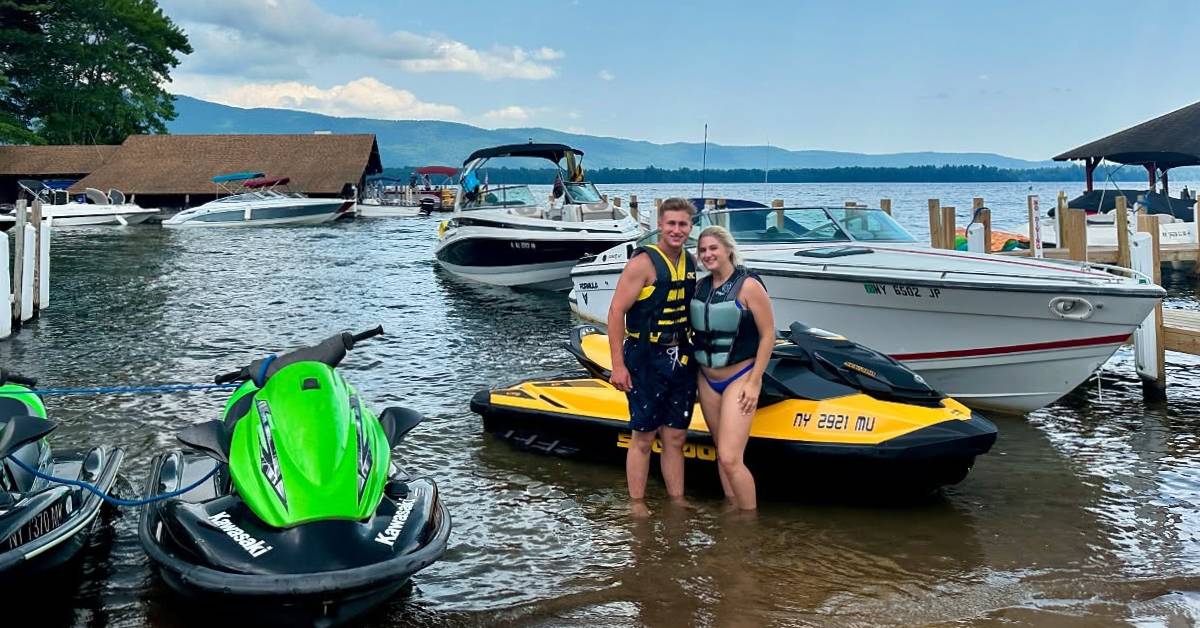 couple poses by boats and jet skis