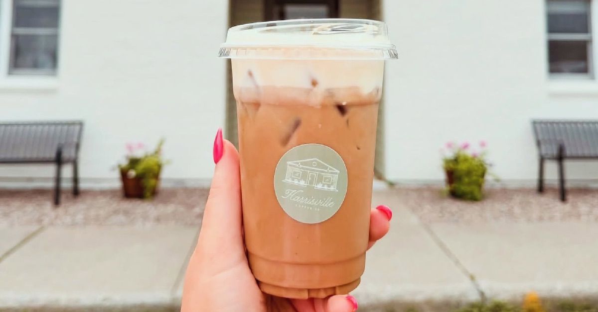 lady holding to-go coffee in front of building